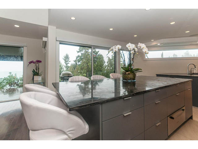 Bright kitchen with marble countertops and hardwood floors, featuring a city view. - 5385 Kew Cliff Rd, West Vancouver
