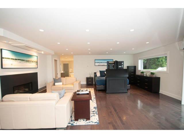 Open-concept living room with hardwood floors and modern furniture. - 5385 Kew Cliff Rd, West Vancouver