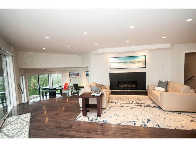 Spacious living room with hardwood floors, large windows, and a city view. - 5385 Kew Cliff Rd, West Vancouver