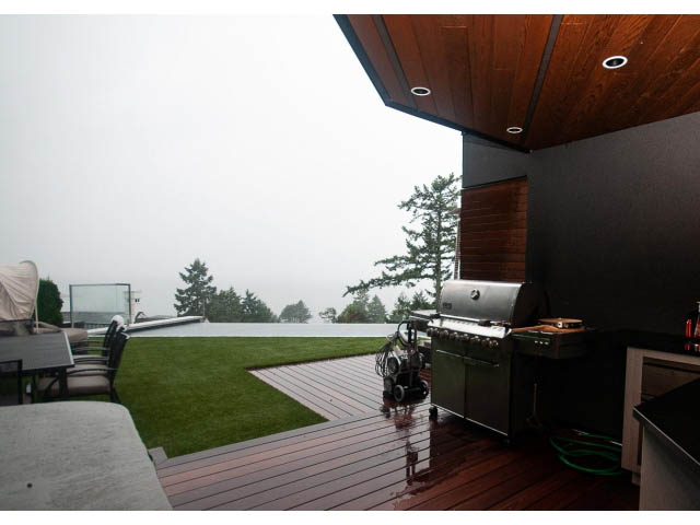Furnished outdoor deck with hardwood flooring, green artificial turf, and modern furniture. - 5385 Kew Cliff Rd, West Vancouver