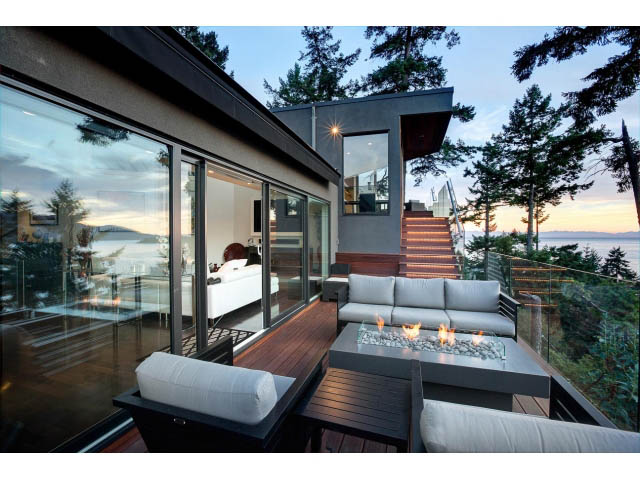 Furnished living room with glass fire pit, ocean view, and modern furnishings. - 5385 Kew Cliff Rd, West Vancouver