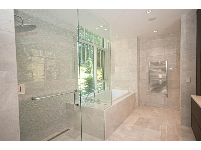 Spacious bathroom with large glass shower, modern fixtures, and neutral stone tiles. - Suite # Withheld - 2958  Burfield Place, West Vancouver