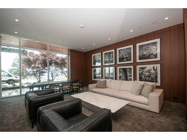 Spacious living room with modern furniture, large windows, and black-and-white artwork on the wall.
