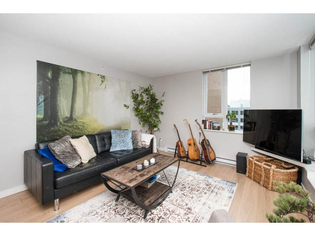Bright living room with hardwood floors, black leather couch, and forest mural. - 1110 - 445 West 2nd Ave, Vancouver West Side