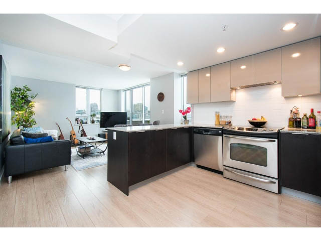 Bright kitchen with modern appliances, hardwood floors, and a cozy living area with a city view. - 1110 - 445 West 2nd Ave, Vancouver West Side