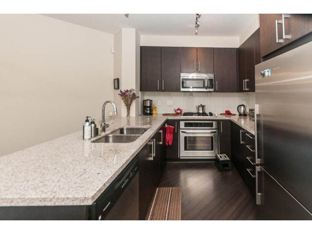 Bright kitchen with granite countertops, hardwood floors, and stainless steel appliances. - 311 - 159 West 22nd Street, North Vancouver