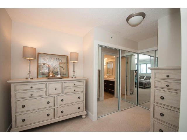 Furnished bedroom with mirrored closet doors and dresser, neutral tones. - 2204 - 1238 Richards Street, Vancouver Downtown