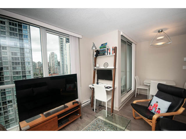 Furnished 1-bedroom living room with city view, modern furniture, and glass coffee table.