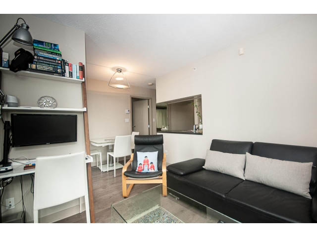 Furnished living room with black leather couch, white walls, and wooden floor. - 2005 - 1408 Strathmore Mews North West One, Vancouver Downtown