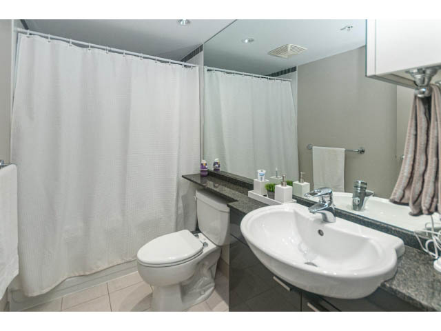 Bright bathroom with white sink, granite countertop, and shower curtain. - 2005 - 1408 Strathmore Mews North West One, Vancouver Downtown