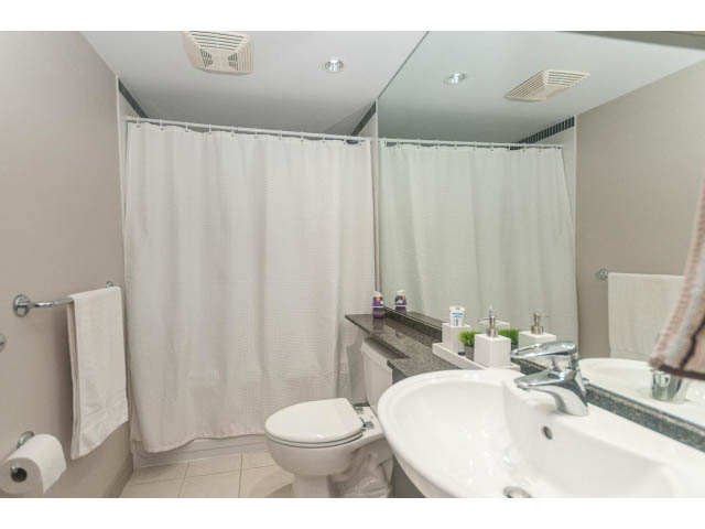 Furnished bathroom with white sink, toilet, and shower curtain. - 2005 - 1408 Strathmore Mews North West One, Vancouver Downtown
