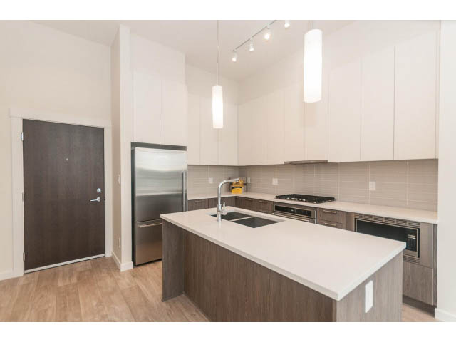 Bright kitchen with white countertops, hardwood floors, and a modern design. - 402 - 625 East 3rd Street, North Vancouver