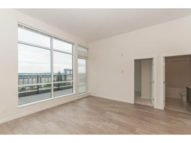 Bright living room with hardwood floors and city view. - 402 - 625 East 3rd Street, North Vancouver