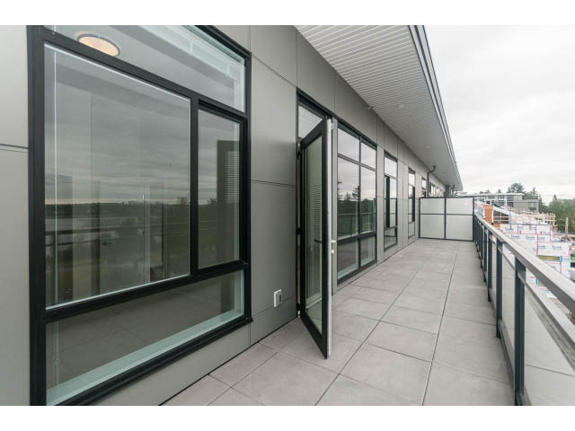 Furnished balcony with modern glass railings and city view. - 402 - 625 East 3rd Street, North Vancouver