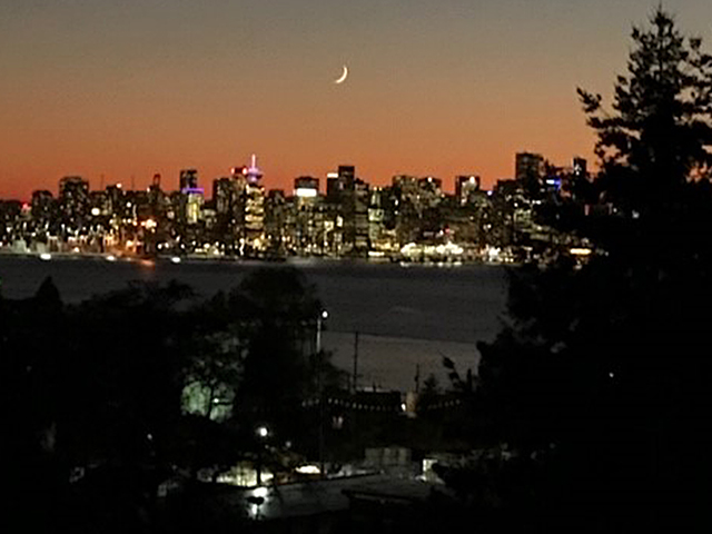 Bright penthouse with stunning city view at dusk, featuring a crescent moon and vibrant skyline. - 402 - 625 East 3rd Street, North Vancouver