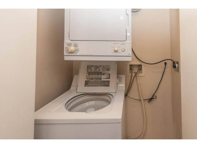 Bright laundry room with stacked washer and dryer, white countertops. - 1506 - 1200 Alberni Street, Vancouver Downtown