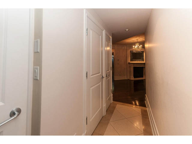 Narrow hallway leading to a cozy living area with a chandelier and wooden accents. - 104 - 533  Waters Edge Cres, West Vancouver