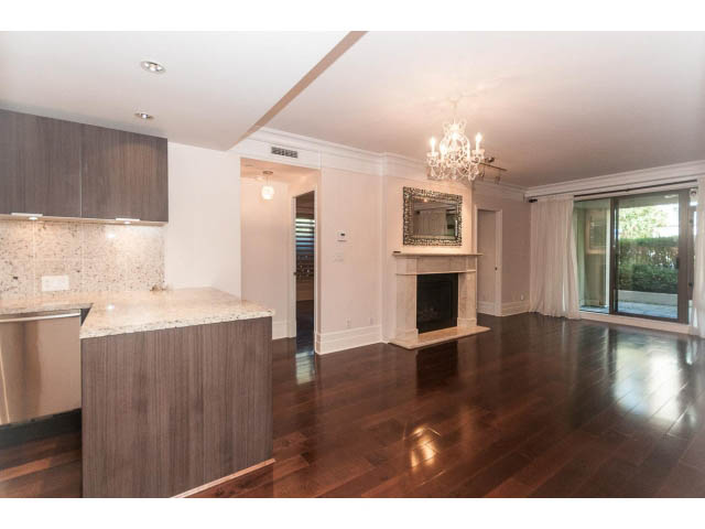 Spacious living room with hardwood floors, granite countertops, and a chandelier. - 104 - 533  Waters Edge Cres, West Vancouver
