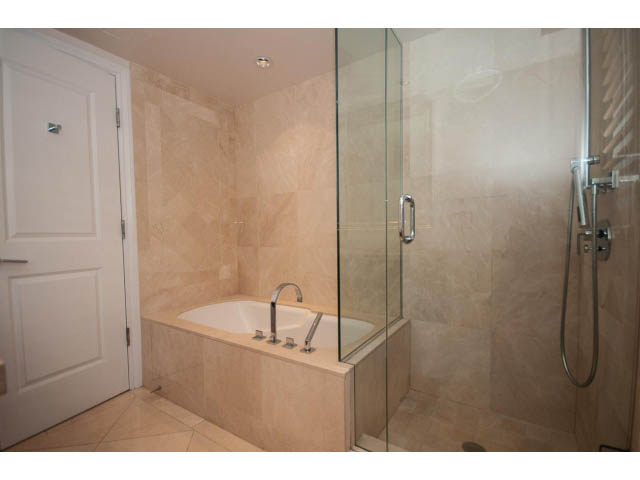 Spacious bathroom with glass shower and beige tile walls. - 104 - 533  Waters Edge Cres, West Vancouver