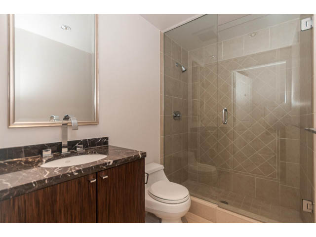 Furnished bathroom with marble countertops and glass shower. - 104 - 533  Waters Edge Cres, West Vancouver