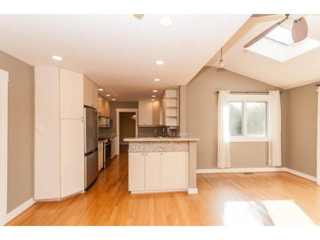 Bright kitchen with light wood cabinets, hardwood floors, and a skylight. - 989 Forest Hills Drive, North Vancouver