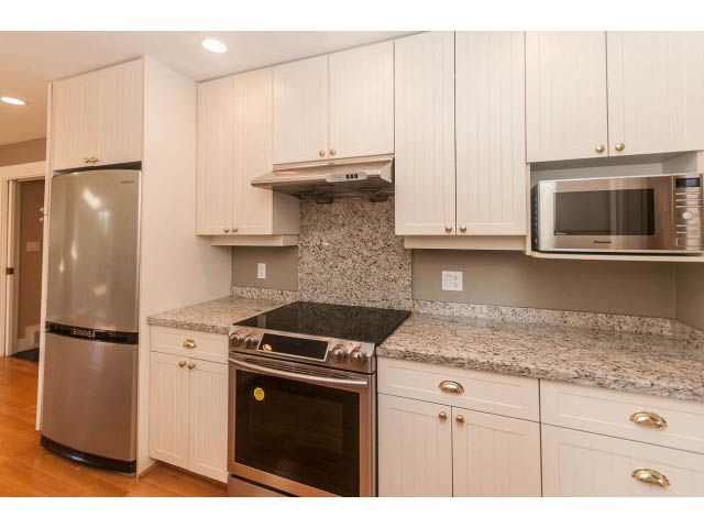 Bright kitchen with granite countertops, stainless steel appliances, and hardwood floors. - 989 Forest Hills Drive, North Vancouver