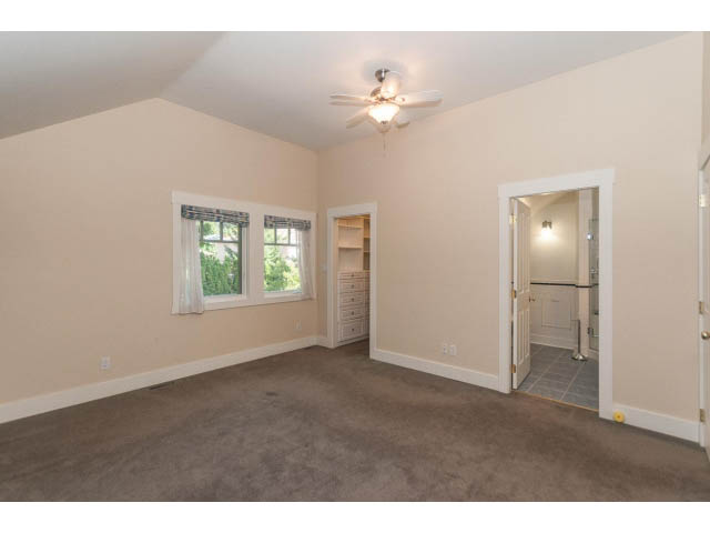 Spacious living room with carpet, double windows, and ceiling fan. - 989 Forest Hills Drive, North Vancouver