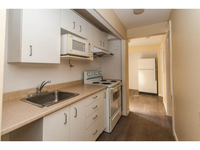 Bright kitchen with light countertops, hardwood floors, and a modern microwave. - 989 Forest Hills Drive, North Vancouver
