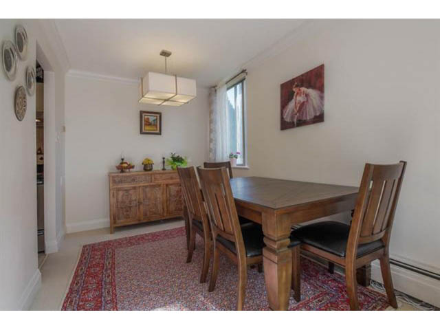 Furnished dining area with wooden table, chairs, and artwork on wall. - 309 - 2008 Fullerton Avenue, North Vancouver