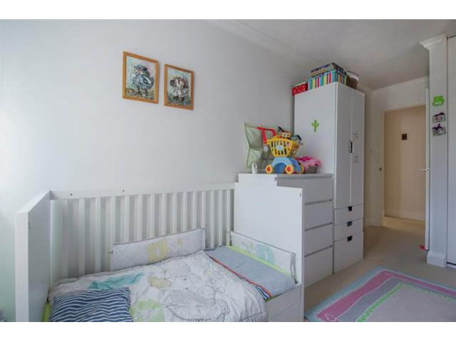 Bright child's bedroom with bunk beds, colorful bedding, and storage units. - 309 - 2008 Fullerton Avenue, North Vancouver
