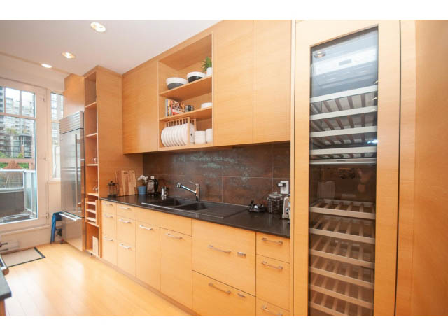 Bright kitchen with wooden cabinets, black countertops, and a city view. - 501 - 1072 Hamilton Street, Vancouver Downtown