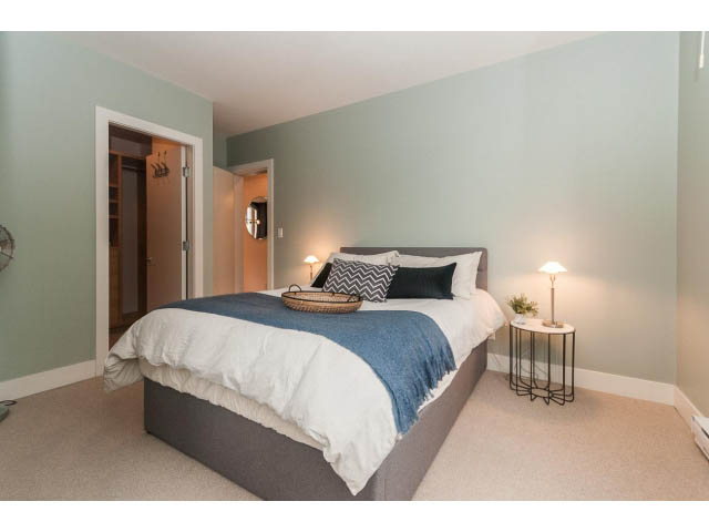 Furnished bedroom with cozy bedding and a bedside lamp. - 501 - 1072 Hamilton Street, Vancouver Downtown