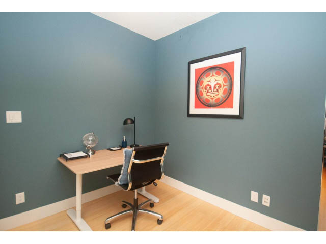 Bright office with teal walls, hardwood floors, and a red sun artwork. - 501 - 1072 Hamilton Street, Vancouver Downtown