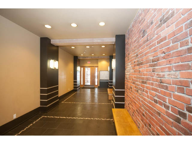 Furnished living room with brick accent wall and modern lighting. - 501 - 1072 Hamilton Street, Vancouver Downtown