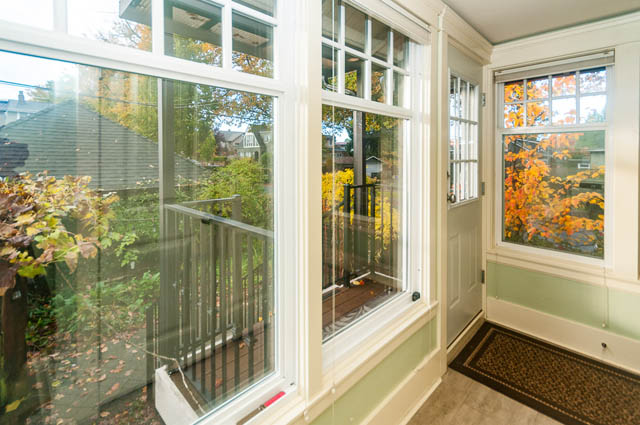 Bright sunroom with large windows, hardwood floors, and autumn foliage outside. - 196 W 18th Avenue, Vancouver West Side