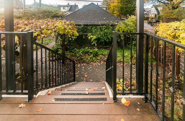 Staircase leading to a garden with autumn leaves, black railings, and wooden steps. - 196 W 18th Avenue, Vancouver West Side