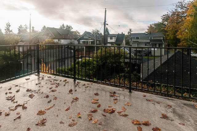 Balcony with railing, scattered leaves, city view. - 196 W 18th Avenue, Vancouver West Side