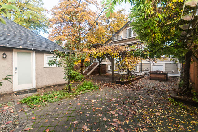 Shared patio with stone paving and autumn leaves, surrounded by trees and houses. - 196 W 18th Avenue, Vancouver West Side