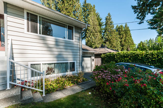 Bright living room with cozy furnishings and lush garden view. - UPPER - 630 East 29th Street, North Vancouver