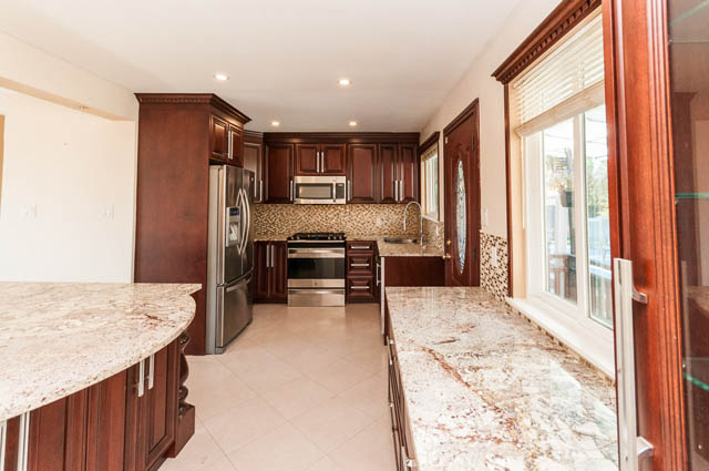 Bright kitchen with granite countertops and dark wood cabinets. - UPPER - 630 East 29th Street, North Vancouver