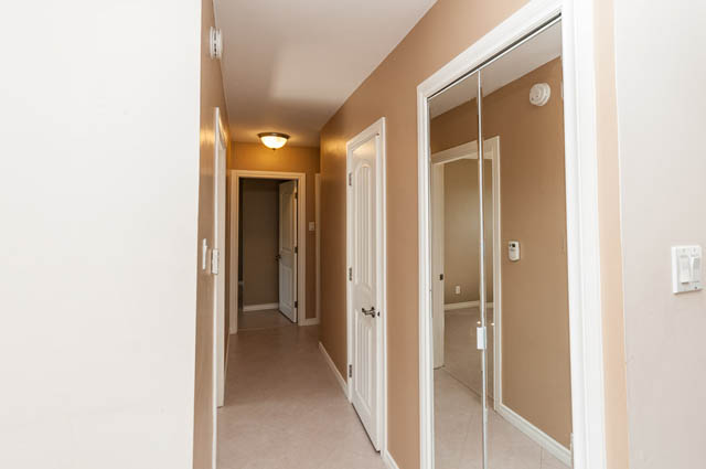Furnished hallway with sliding closet doors and beige walls. - UPPER - 630 East 29th Street, North Vancouver