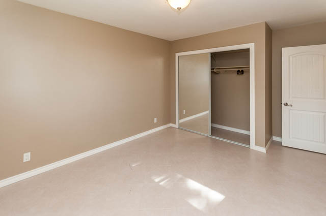 Bright bedroom with sliding closet doors and beige walls. - UPPER - 630 East 29th Street, North Vancouver