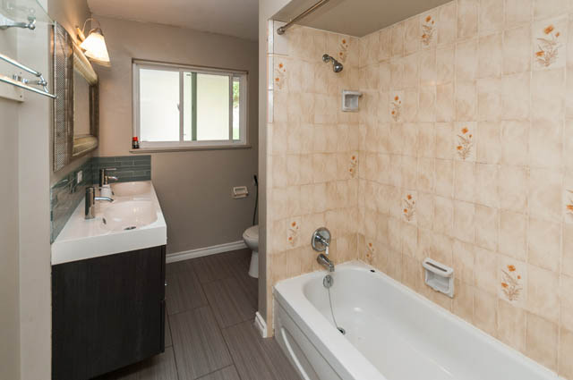 Bright bathroom with beige tile walls and modern sink. - UPPER - 630 East 29th Street, North Vancouver