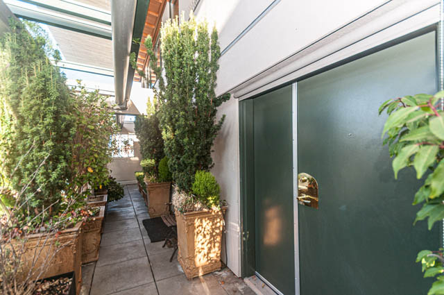 Bright living room with large windows, greenery, and modern furnishings. - PH7 - 1688 Robson Street, Vancouver Downtown