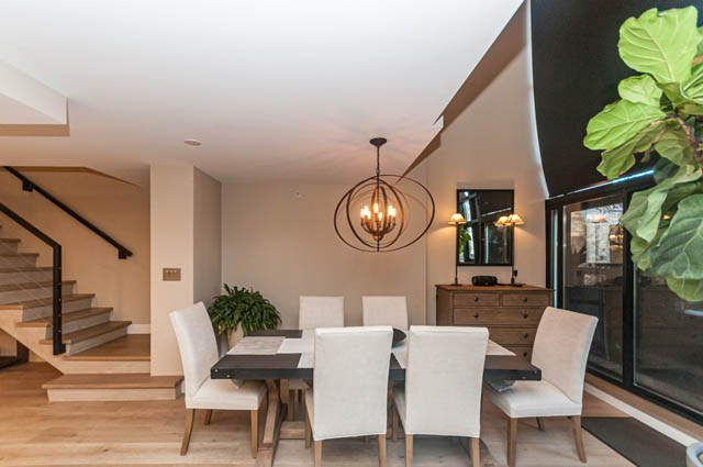 Bright dining area with modern chandelier, hardwood floors, and city view. - PH7 - 1688 Robson Street, Vancouver Downtown