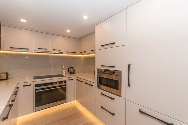 Bright kitchen with white cabinets, stainless steel appliances, and hardwood floors. - PH7 - 1688 Robson Street, Vancouver Downtown