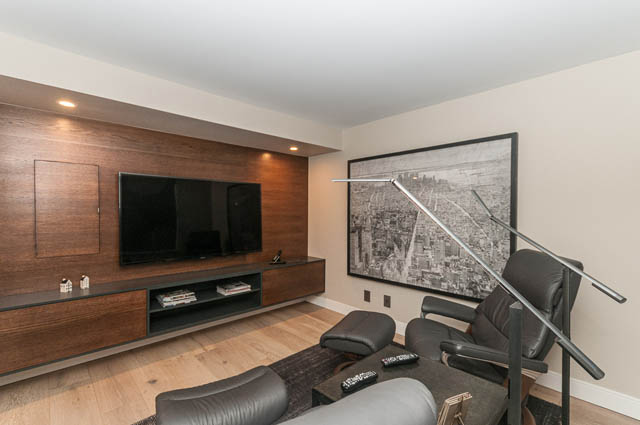 Living room with modern furniture, large TV, and cityscape artwork. - PH7 - 1688 Robson Street, Vancouver Downtown