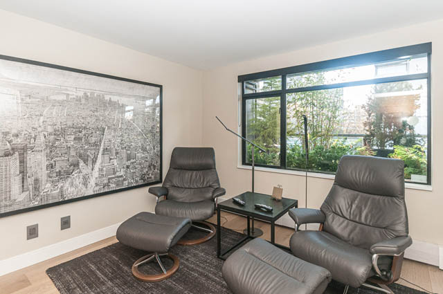 Bright living room with cityscape mural and large windows, showcasing a serene outdoor view. - PH7 - 1688 Robson Street, Vancouver Downtown