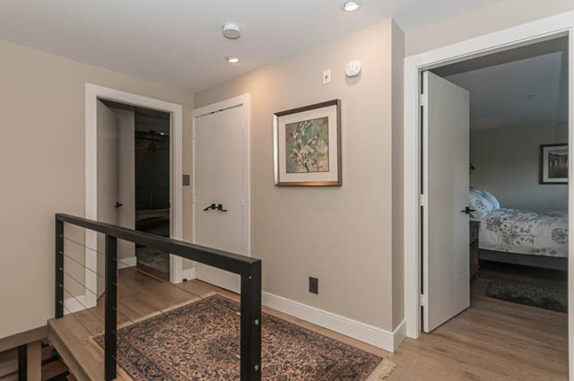 Bright hallway leading to bedrooms with hardwood floors and a staircase. - PH7 - 1688 Robson Street, Vancouver Downtown