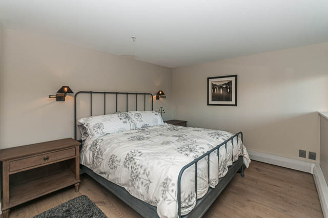 Spacious bedroom with wooden floors, modern bed, and wall art. - PH7 - 1688 Robson Street, Vancouver Downtown